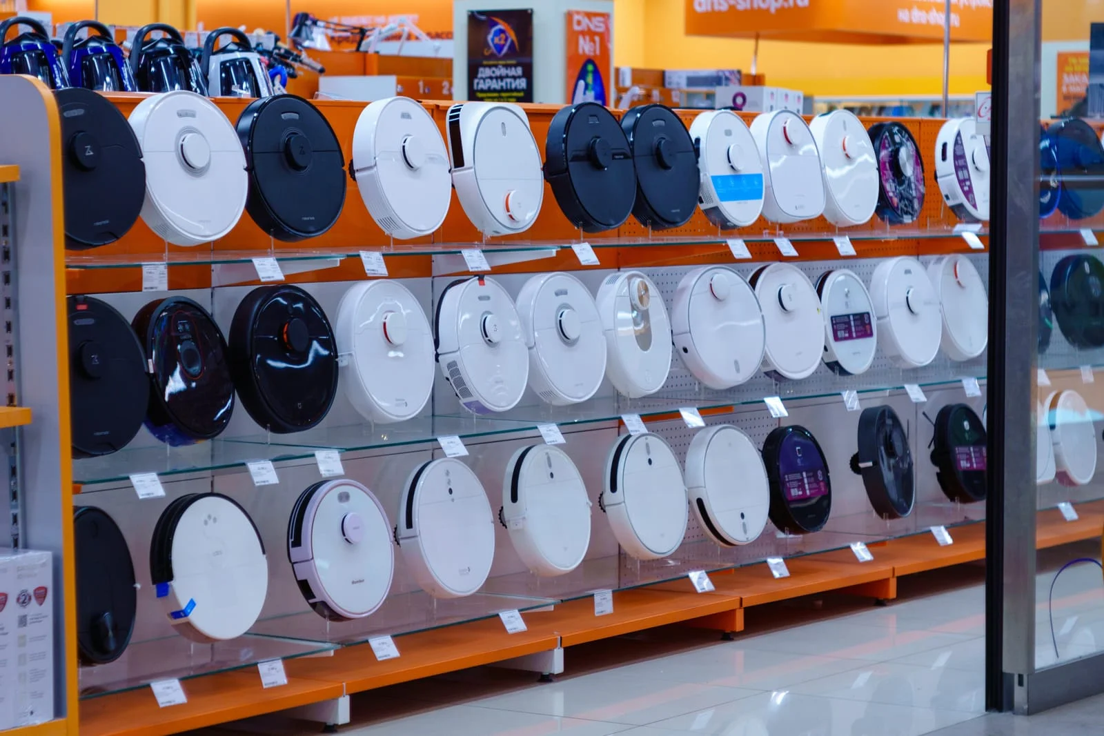 lots of robot vacuum cleaners on a shelf in a gadget electronics and home appliance store
