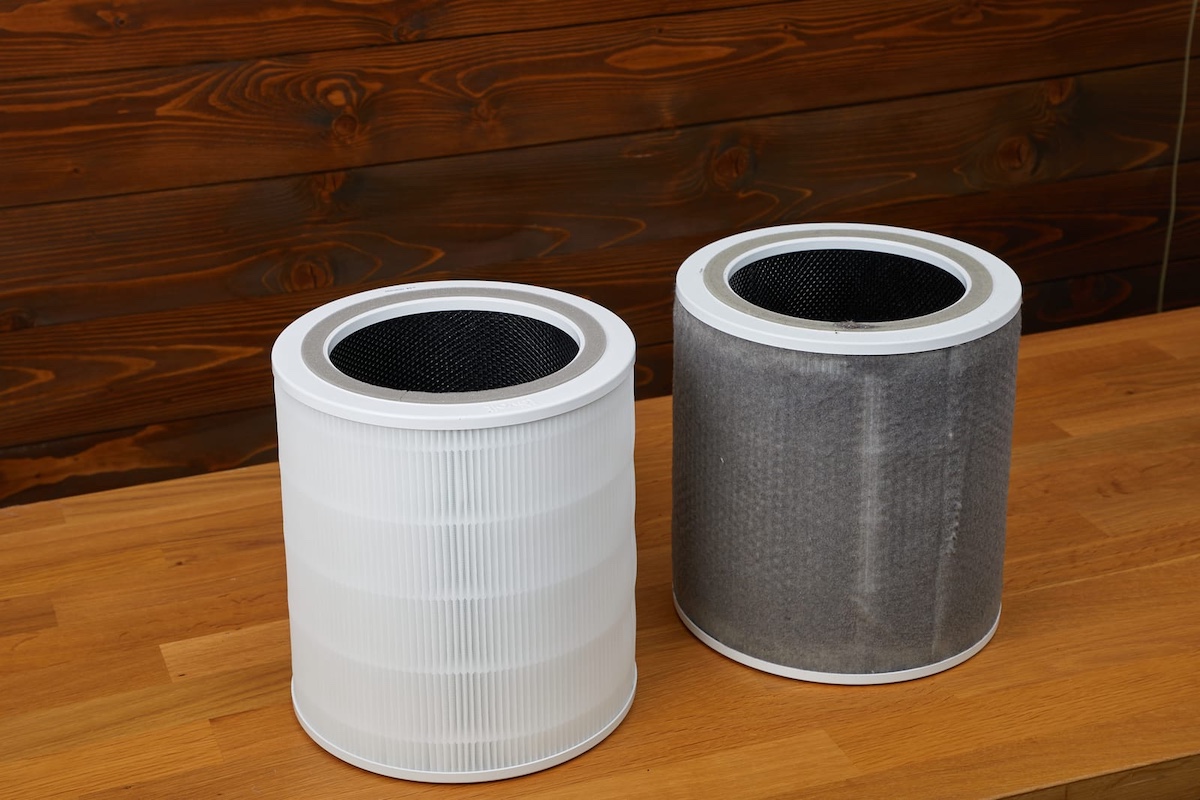 attractive woman with air purifier on windowsill