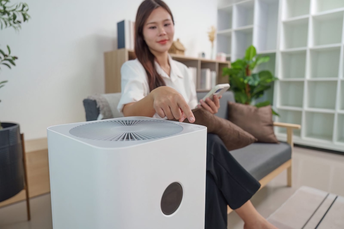 air purifier control user adjusting air purifier settings with smartphone