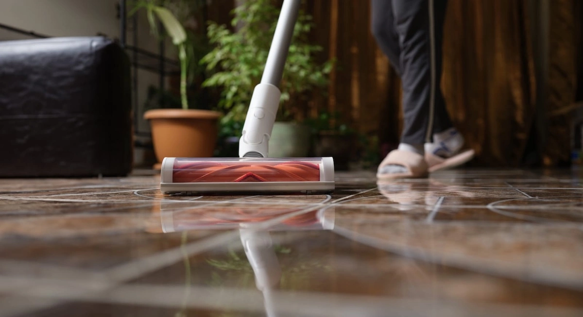 cordless vacuum cleaner with turbo brush cleans tiles in living room