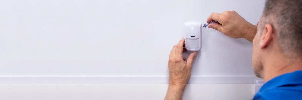 electrician installing security system door sensor